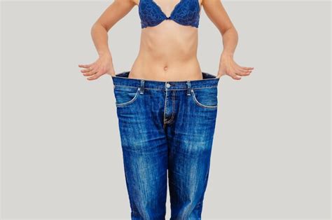 Premium Photo Woman Shows Weight Loss In Old Big Jeans
