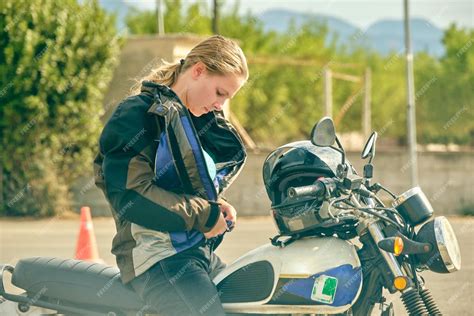 premium photo side view of serious female motorcyclist sitting on contemporary motorbike and