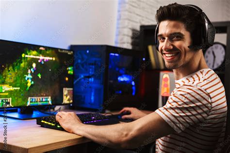 Foto De Image Of Cheerful Gamer Man Playing Video Games On Computer