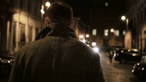 Back View Of Young Stylish Man Walking Late At Night Through The Dark