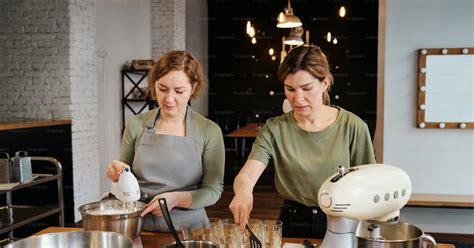 Foto Dos Mujeres En Una Cocina Mezclando Comida Cocinando Imagen En