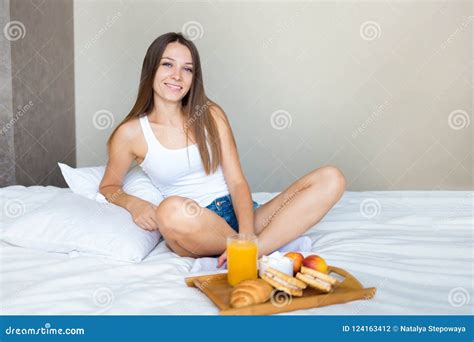 Beautiful Brunette Girl Eating A Healthy Breakfast In Bed And Smiling
