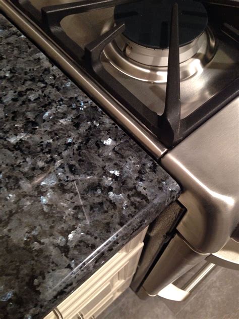 The blue granite features various shades of blues, grays, and blacks to create an absolutely stunning granite slab. Blue pearl granite, antique white cabinets and stainless ...