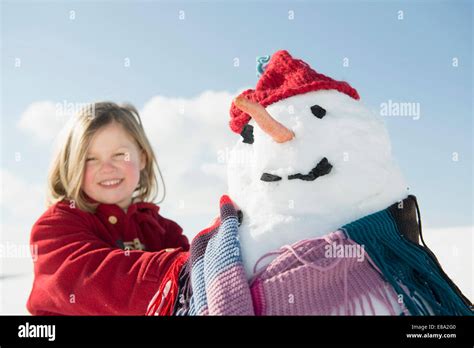 Portrait Of Girl Standing With Snowman Smiling Bavaria Germany Stock