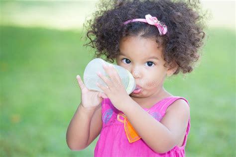 Cute Latin Girl Drinking From A Baby Bottle Royalty Free Stock Photo