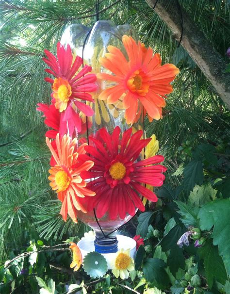 I made these using an old red plastic coffee container, cut into little petal. Plastic Bottle Hummingbird Feeder | Humming bird feeders ...