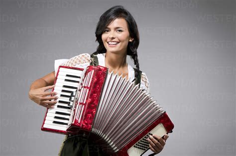 Portrait Of Smiling Young Woman Playing Accordion Stock Photo