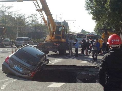 In Pictures Huge Sinkhole Swallows Car Just Moments After Driver Makes