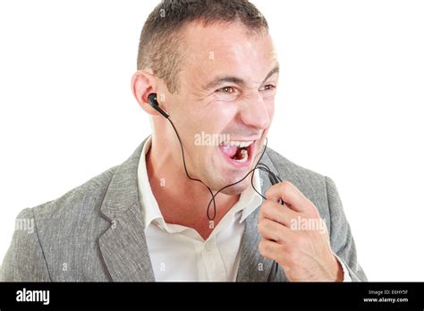Angry Man With Earbuds Connected On Mobile Phone Yelling While Talking Over Phone Microphone