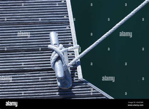 Boat Rope Tied To A Metal Cleat On Wood Plank Dock Stock Photo Alamy