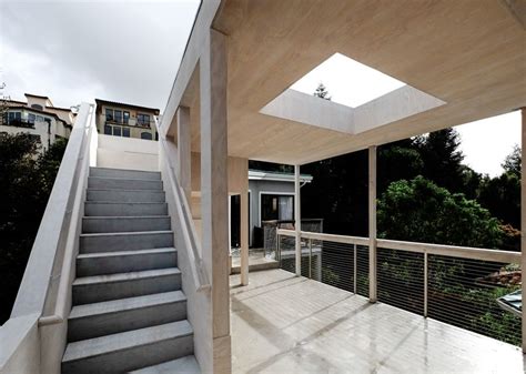 the stairs lead up to the upper level of this modern house with skylights above