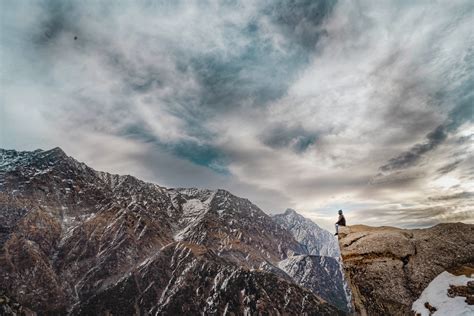 A Man Sitting On A Mountain Peak Pixeor Large Collection Of
