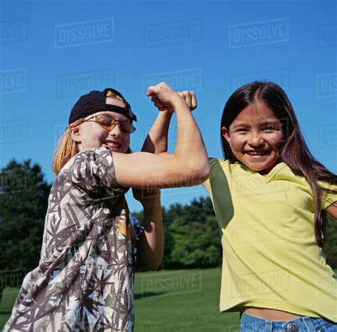 Smiling Girls Flexing Biceps Outdoors Stock Photo Dissolve