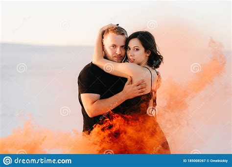 Guy And A Girl In Black Clothes Hug And Run On The White Sand Stock Image Image Of Together