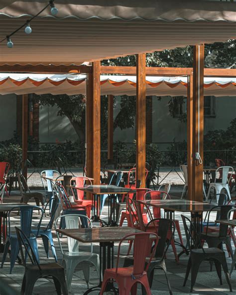 Outdoors Empty Cafe Tables And Chairs On A Sunny Day Free Photo