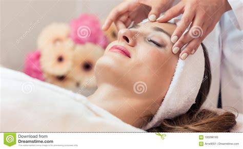 Beautiful Woman Relaxing During Rejuvenating Facial Massage In A Stock