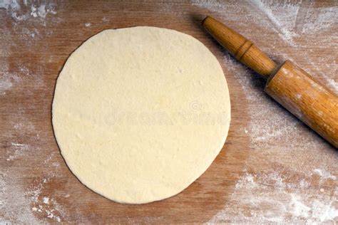 Rolled Dough On A Wooden Board Sprinkled With Flour And Rolling Pin