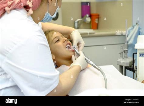 Young Girl Has Her Teeth Cleaned By A Dental Hygienist At The Dentist