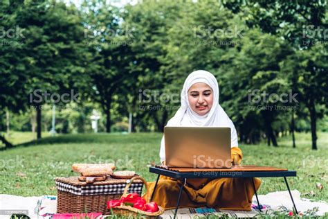 Portrait Of Happy Arabic Muslim Woman With Hijab Dress Smiling And Using Laptop Cumputer In