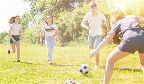 Company Of Glad Teenagers Playing Football Stock Image Image Of