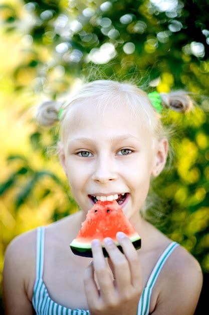 Premium Photo Adorable Blonde Girl Eats A Watermelon Outdoors
