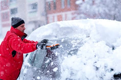 Men Cleaning Car Windshield From Snow And Ice After Snow Storm Stock