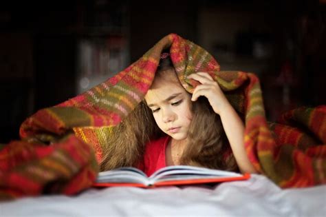 Niño leyendo un libro en la cama Foto Premium