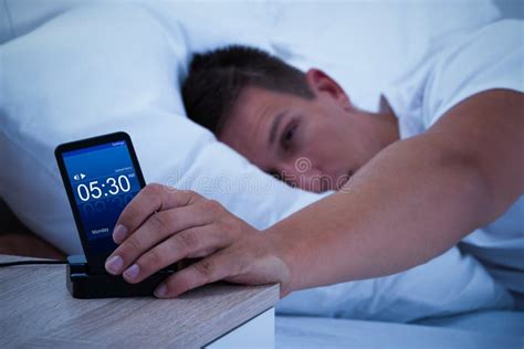 Man Waking Up With Mobile Alarm Clock Stock Photo Image Of Male