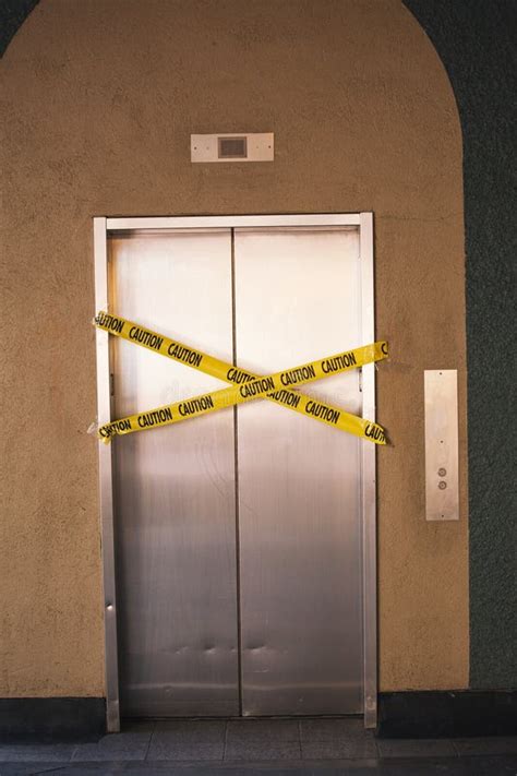 elevador fuera de servicio con señales de advertencia de cinta amarilla imagen de archivo