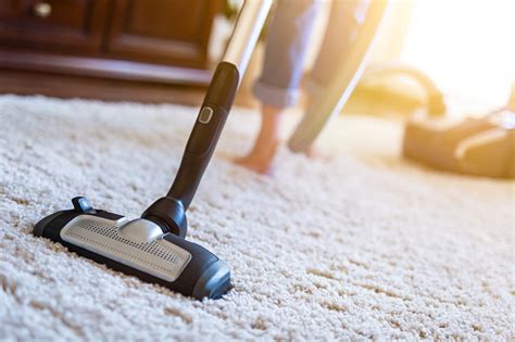 Woman Using A Vacuum Cleaner While Cleaning Carpet In The House Stock