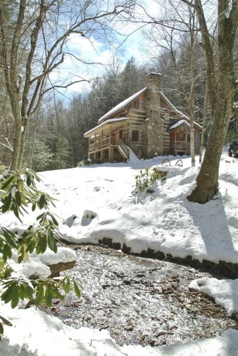 A Log Cabin In The Woods With Snow On The Ground And Trees Around Its Edge