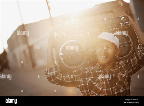 A Young Man With A Boombox On His Shoulder On The Street Of A City