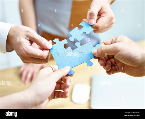 Group Of Business People Putting Jigsaw Pieces Together Stock Photo Alamy