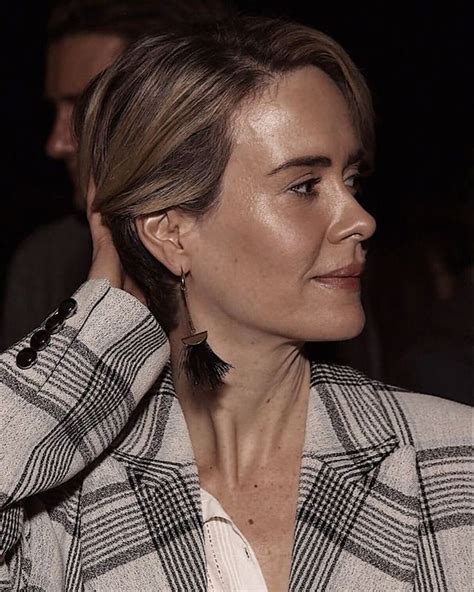 A Woman In A White Shirt And Black Jacket Is Looking Off To The Side
