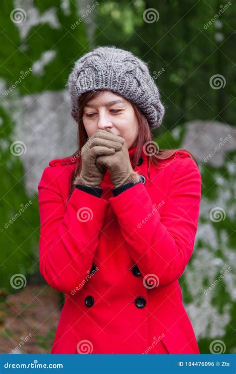 Young Woman Shivering With Cold And Blowing Hot Air To The Hands On A