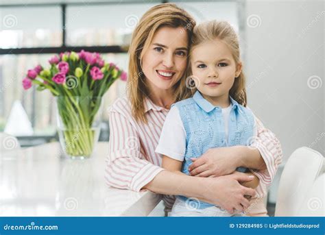 Retrato De La Madre Sonriente Que Abraza A Poca Hija Imagen De Archivo