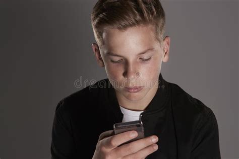 White Teenage Boy Using Mobile Phone Head And Shoulders Stock Photo