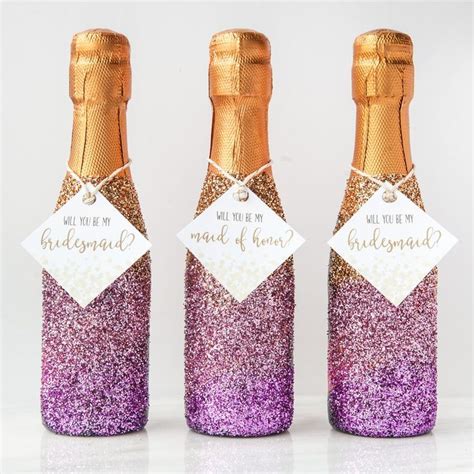 Three Wine Bottles With Purple And Gold Glitter On Them One Has A