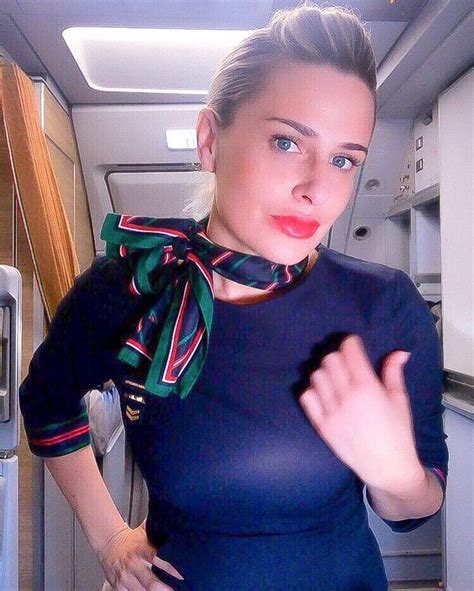 A Woman Is Standing In An Airplane With Her Hand On Her Hip And Looking At The Camera