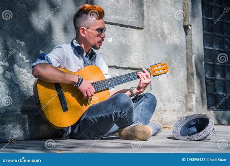 Street Musician Playing The Guitar Outdoors On The Street Stock Image