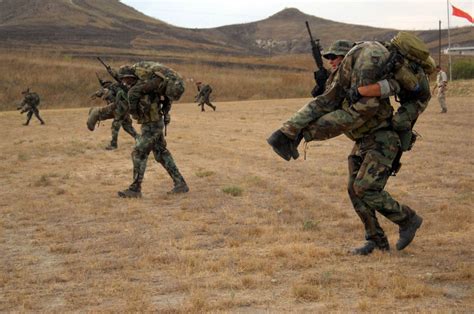 Soldiers In Camouflage Are Running Through The Field