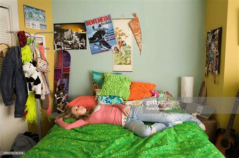 Teenage Girl Lying On Bed Staring At Ceiling Elevated View Photo