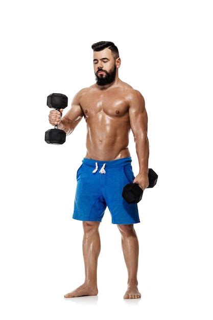 Hombre atlético musculoso haciendo ejercicios con pesas culturista fuerte con el torso desnudo
