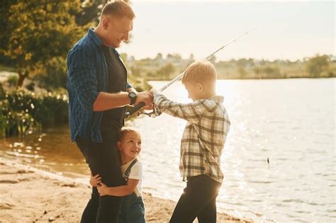 Padre Con Hijo E Hija Pescando Juntos Al Aire Libre En Verano Foto