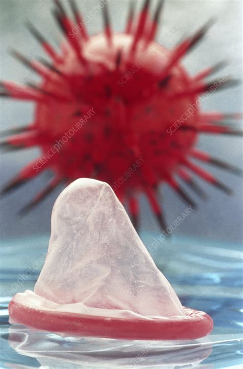 view of a condom and a model of an aids virus stock image m860 0180 science photo library