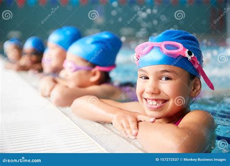 Portrait Of Children In Water At Edge Of Pool Waiting For Swimming