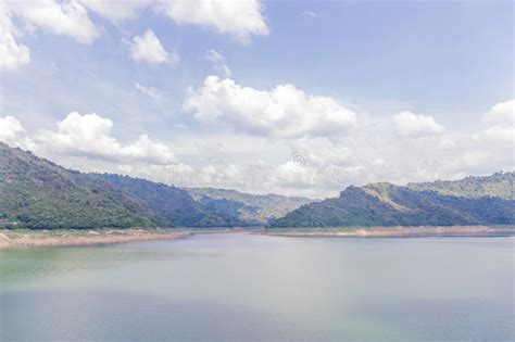 Landscape Of Natural Dam Mountain And Water Reservoir Under Cloudy Sky
