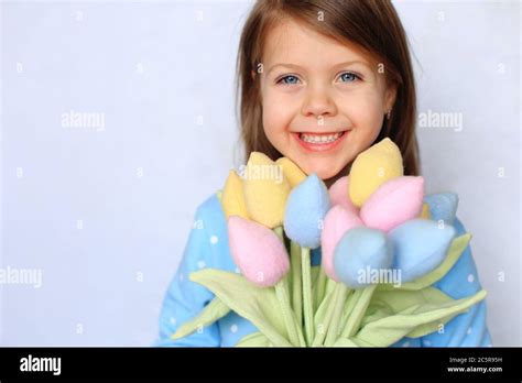 Beautiful Blue Eyed Girl Stands With Flowers In Her Hands Stock Photo