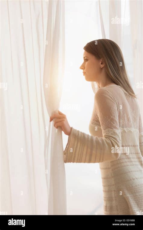 Young Woman Opening Curtains In Morning Stock Photo Alamy