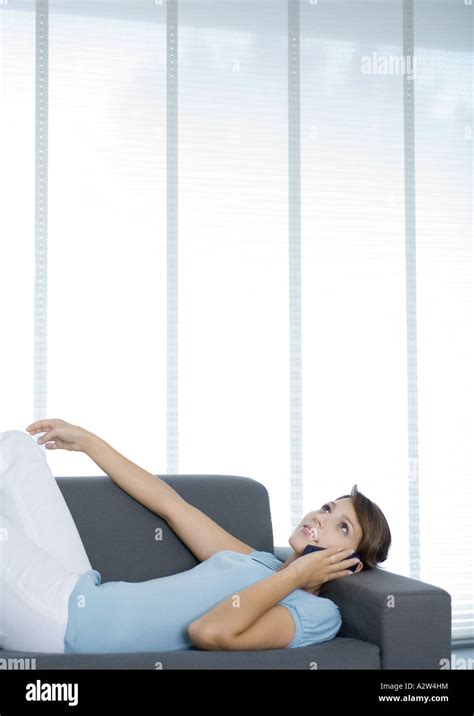 Woman Lying On Sofa Using Cell Phone Stock Photo Alamy
